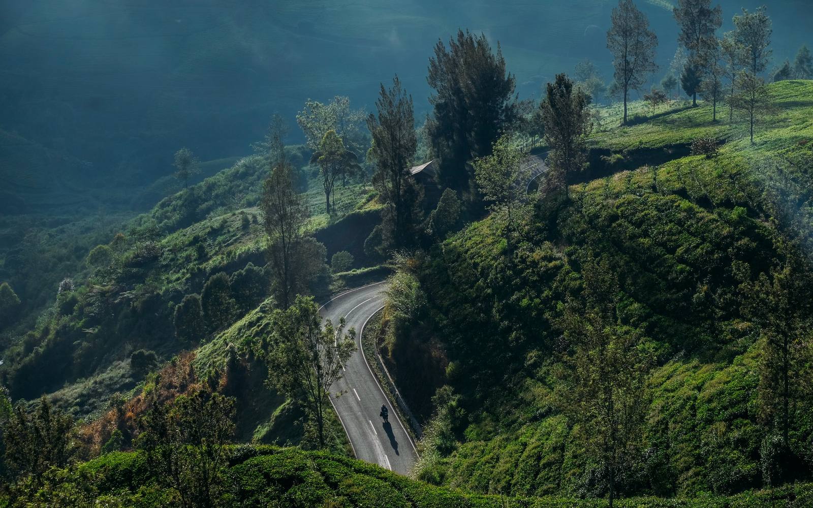 An aerial view of a road winding through mountains near Bandung
