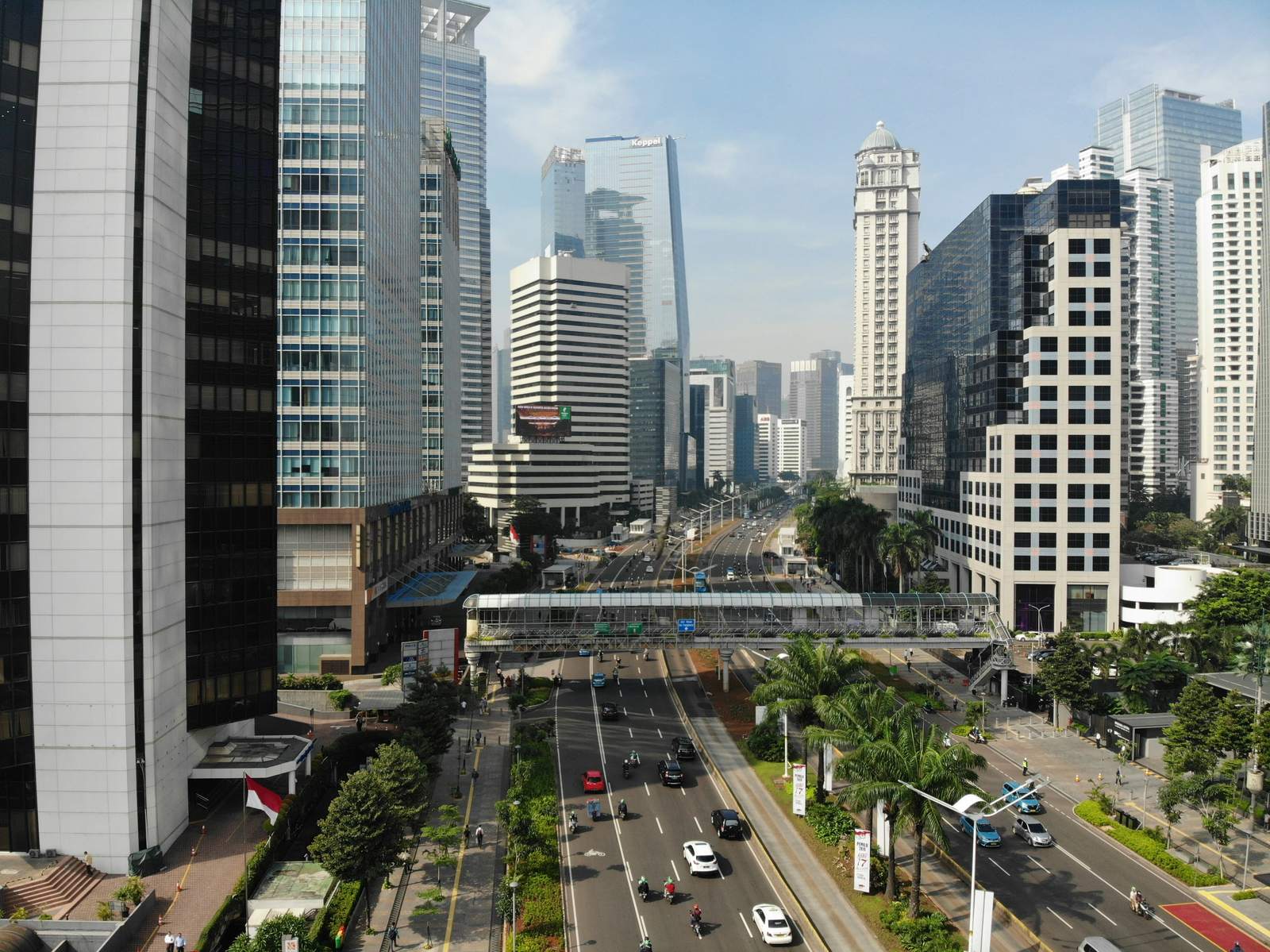 Traffic and a pedestrian bridge over a wide road in Jakarta